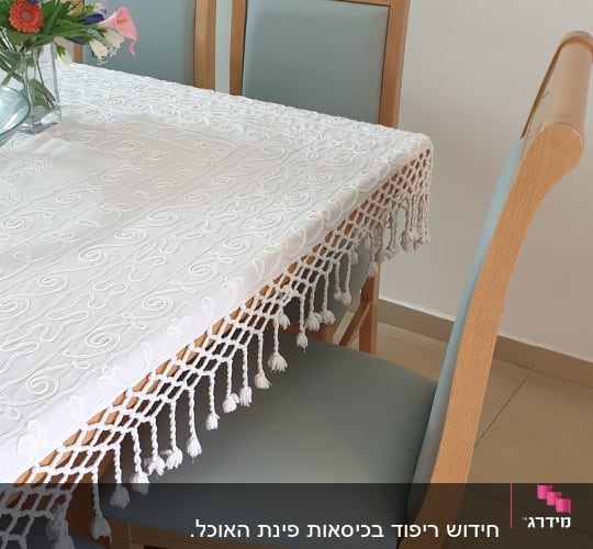 כיסאות מרופדים ליד שולחן עם מפה לבנה